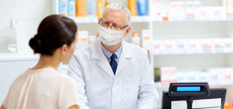 A pharmacist speaking with a customer in a pharmacy