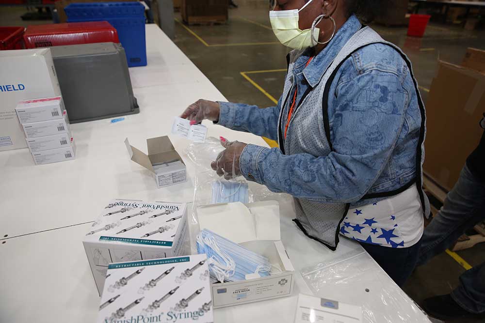 A DC worker assembles ancillary supply kits for COVID-19 vaccines.