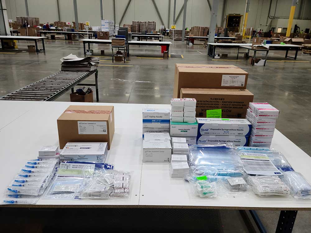 Displayed on the table above are ancillary supply kits for Moderna's vaccine (left) and for Pfizer's (right).