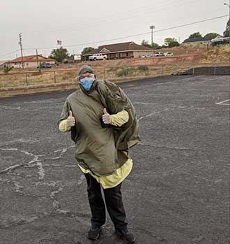 Jordan Call, owner, CEO and pharmacy manager of Call’s Community Pharmacy in Snowflake, Arizona, dresses in full PPE as he prepares to administer onsite COVID-19 tests.