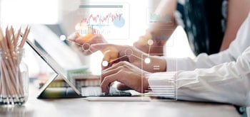 Icons representing analytics on top of a photo of hands at a computer