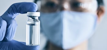 A lab worker holding a vial