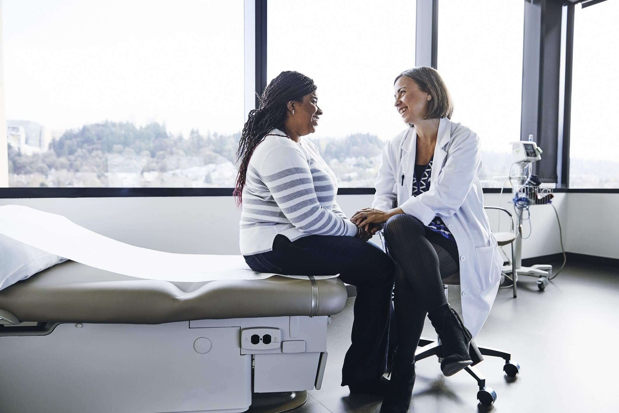 A doctor and patient sitting in a bright medical office, engaging in a caring conversation.