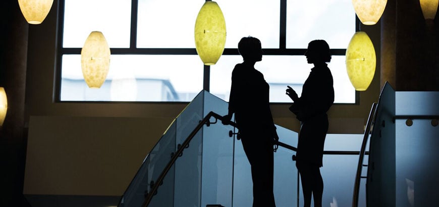 Two people having a conversation on a staircase