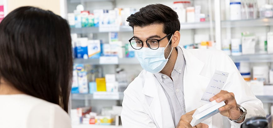 A pharmacist reviewing prescription drug information with a customer