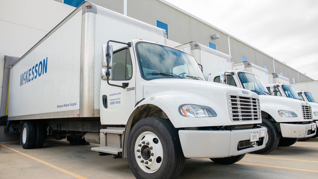 White McKesson delivery trucks parked in front of a warehouse.
