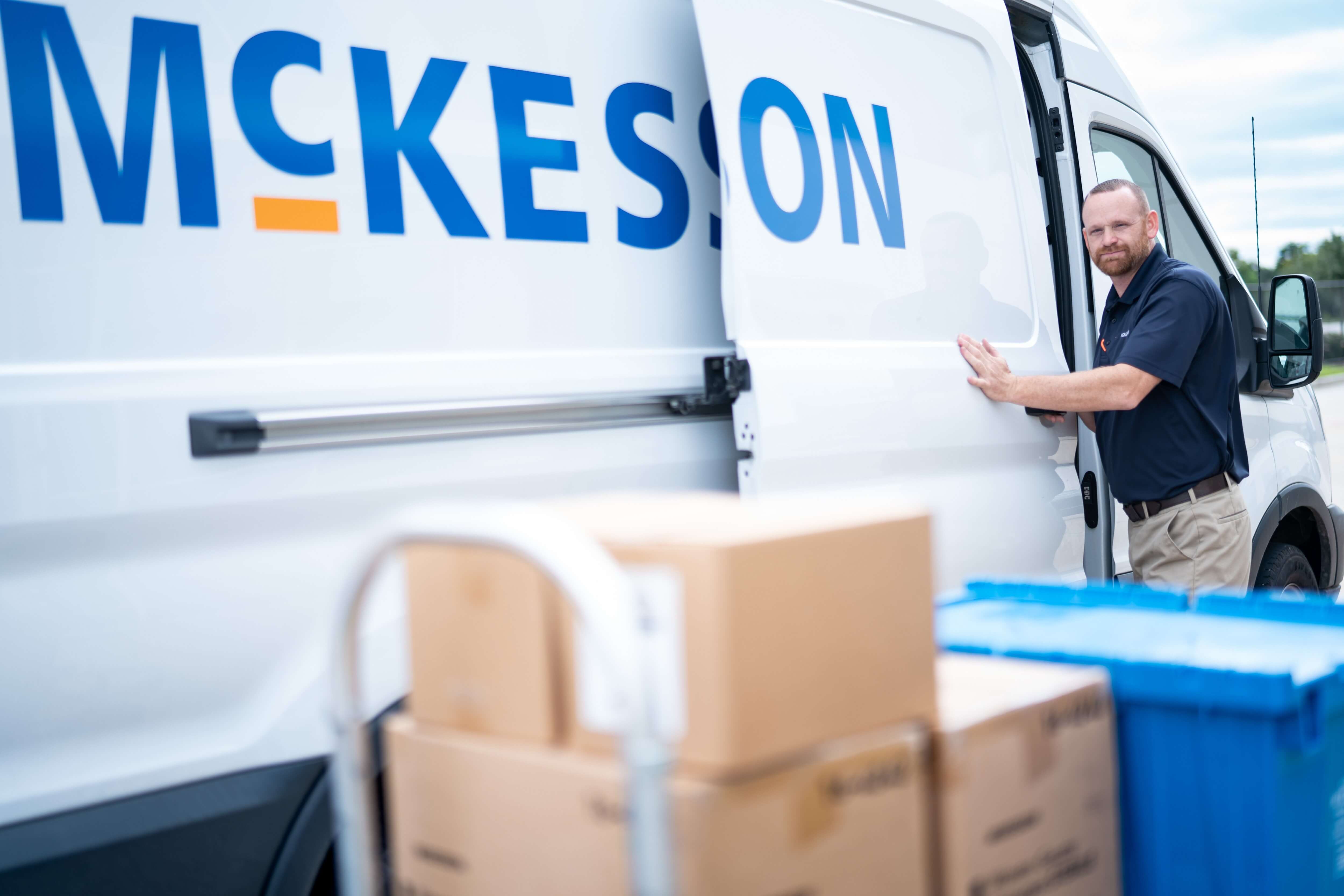 Person loading boxes into a McKesson delivery van.