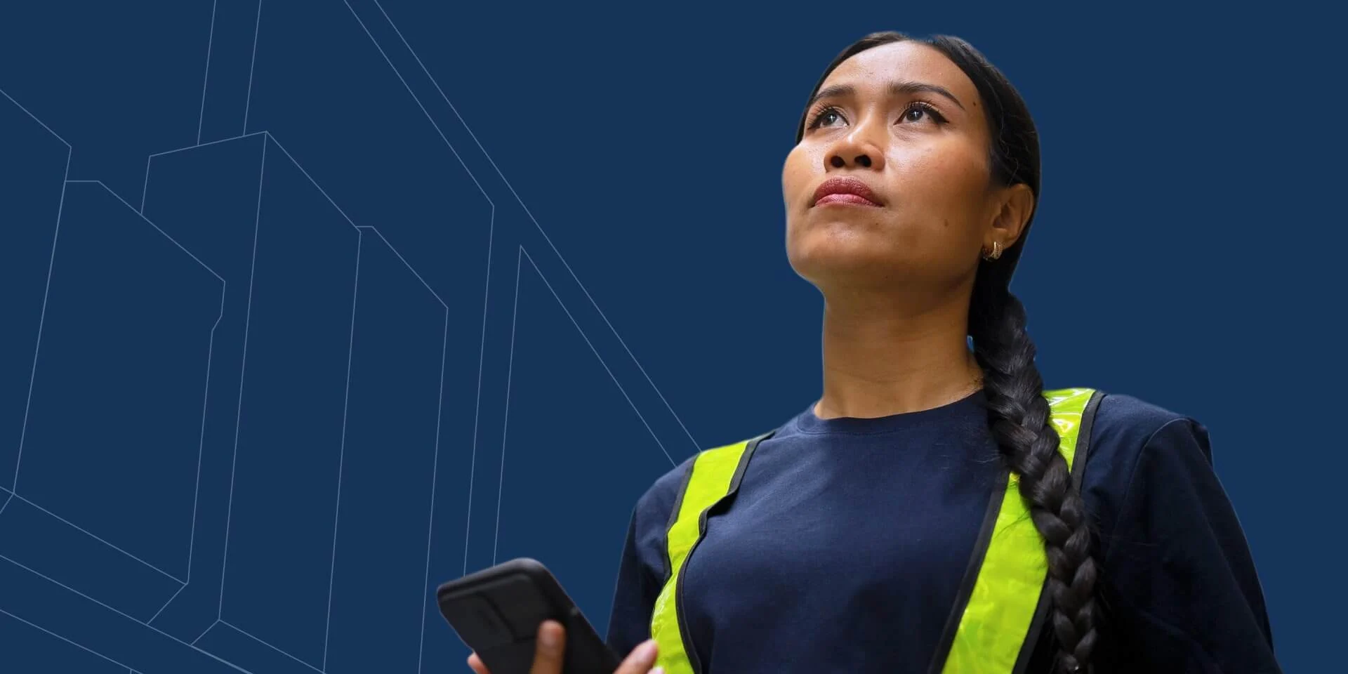 Person in a dark shirt with a reflective vest holding a smartphone and a barcode scanner against a solid blue background.