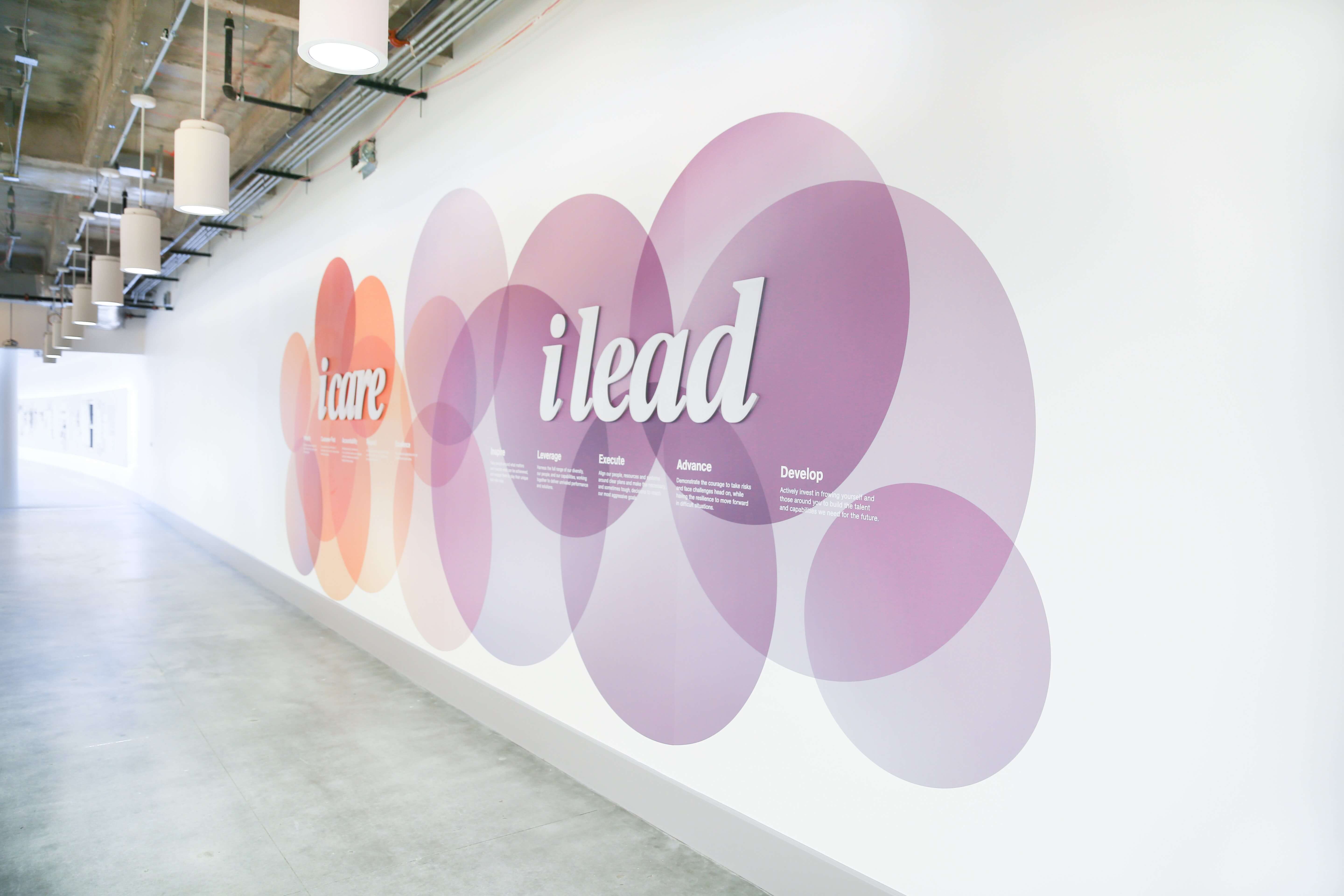 Wall with overlapping circles displaying the words 'icare' and 'ilead' in a hallway.