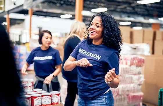 Two people in McKesson shirts working in a warehouse with canned goods.