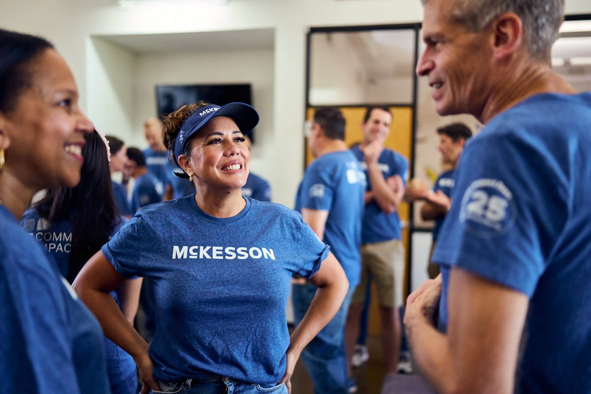 Group of people wearing blue McKesson shirts in a room, some with blurred faces.