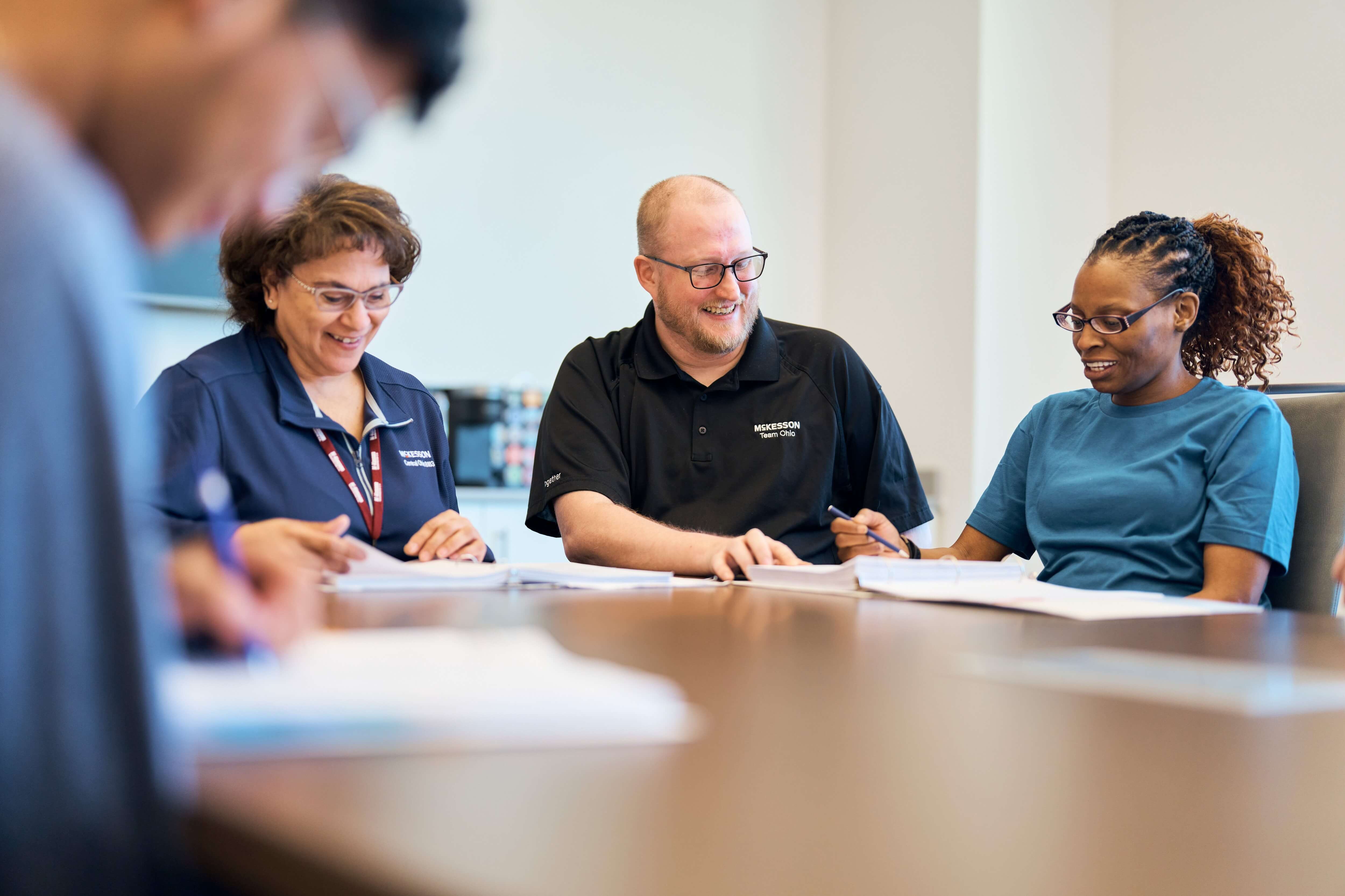 Four people sitting at a table having a discussion with documents in front of them.