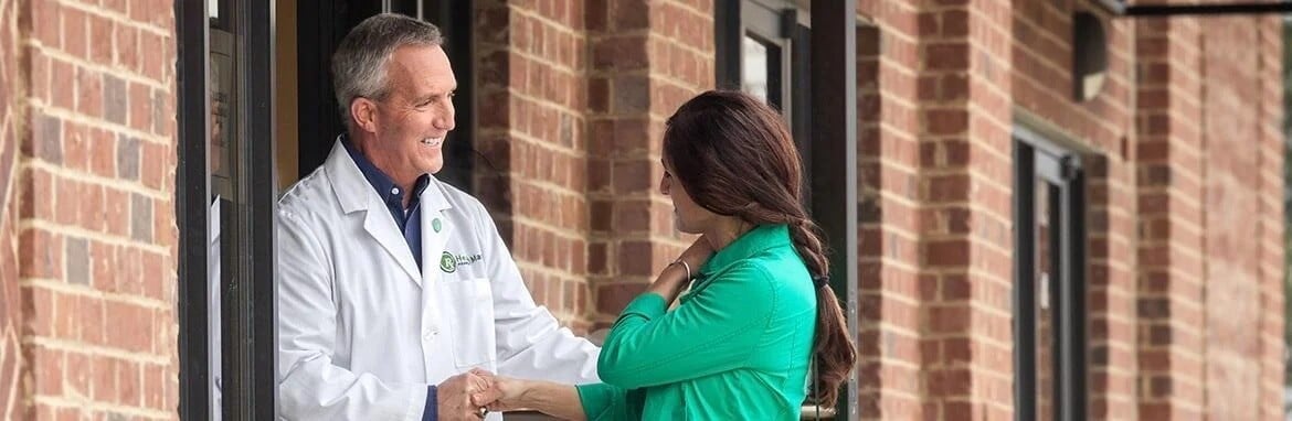 A pharmacist greeting a woman.