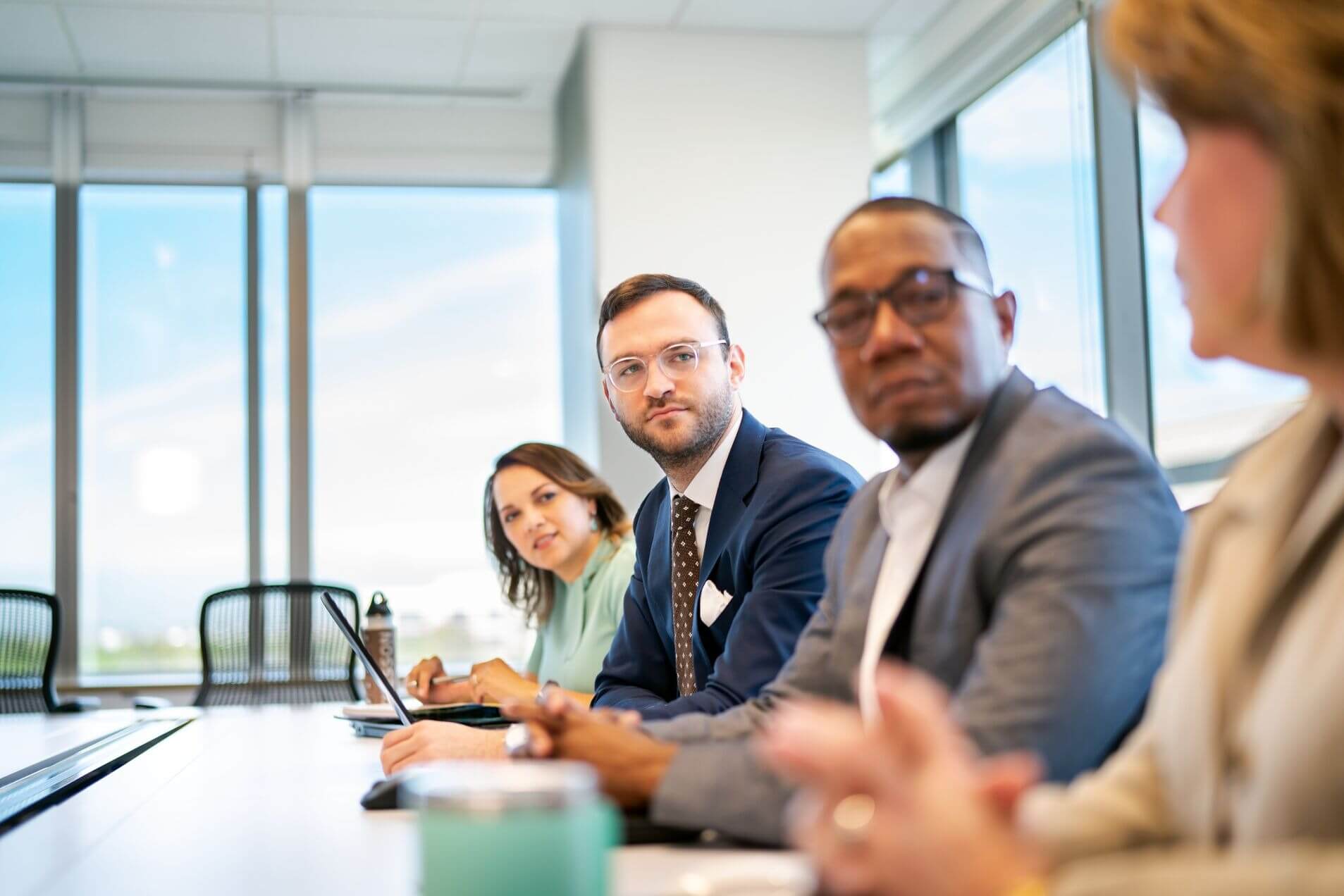 People sitting at an office conference table. 