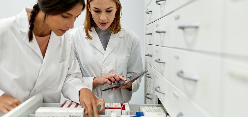 <span>Two female pharmacists sorting medicines in the storage area. </span>