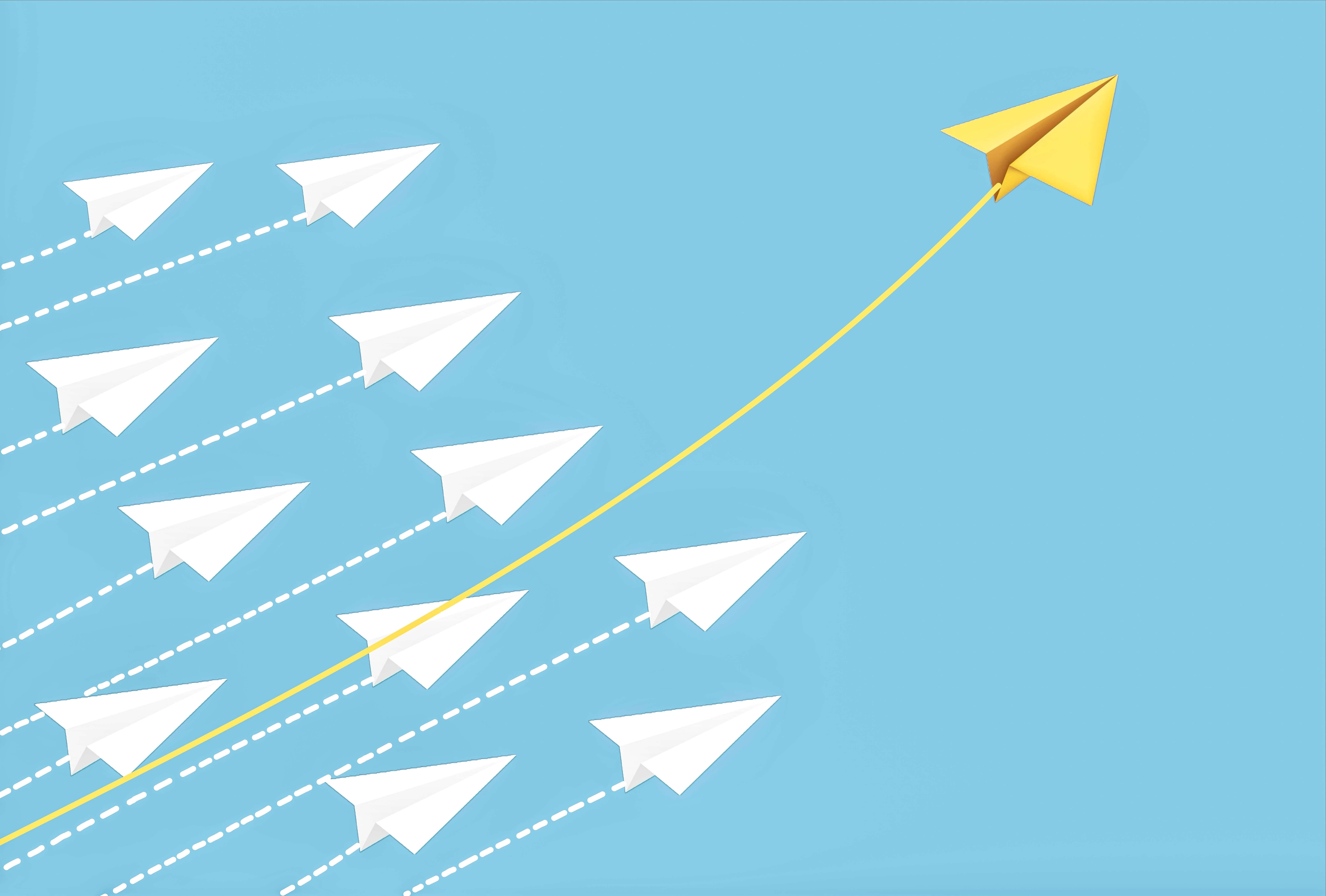 A group of white paper airplanes flying in formation, with one yellow paper airplane breaking away and flying higher on a different path.