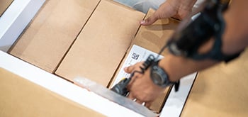 A person picking up a box