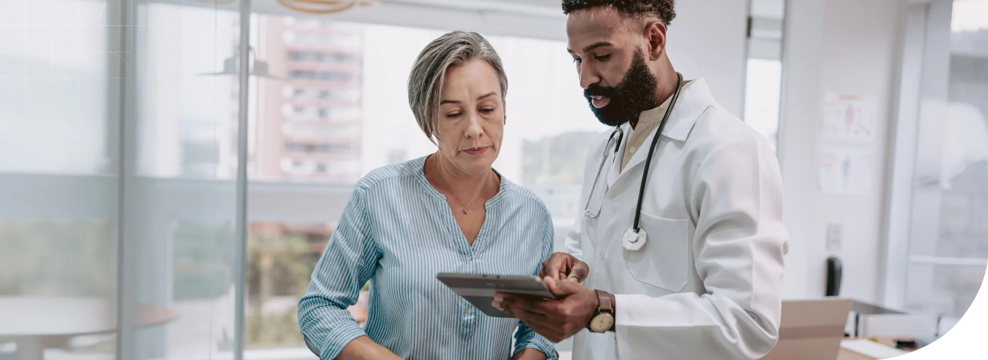a physician and a patient looking at a hand-held table