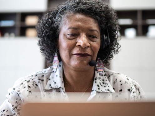 A woman sitting in front of a computer with a headset on