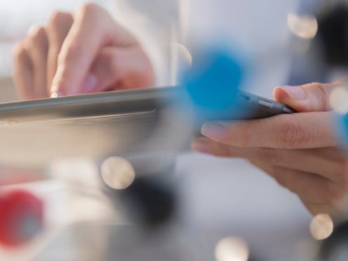 Close up of hands holding a tablet