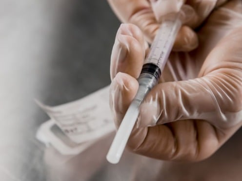 A closeup of a doctor holding an intravenous needle
