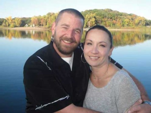 Becky and her husband embrace each other while standing by Lake Superior