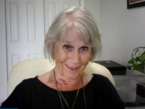 An older woman sitting in a chair smiling