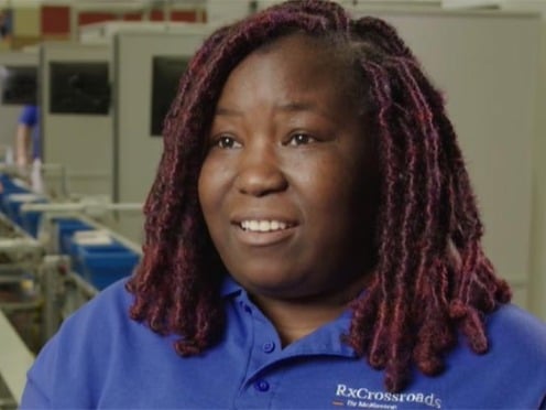A person speaking in front of an assembly line in a distribution center