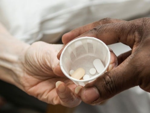 Close up of hands as one person hands another medication.