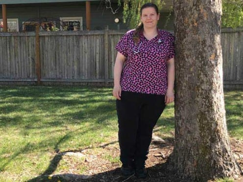 A nurse leaning against a tree