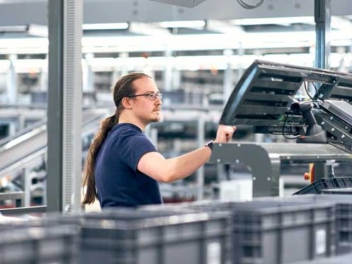 A worker stands at the assembly line