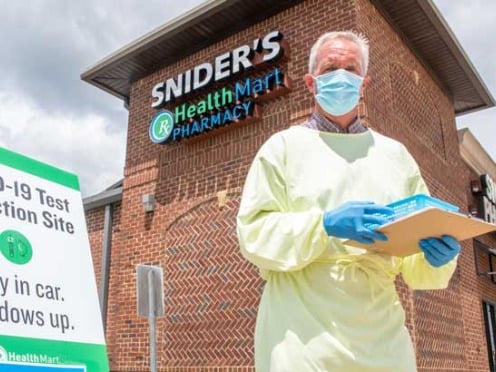 A healthcare worker standing in front of a Snider's Health Mart pharmacy building