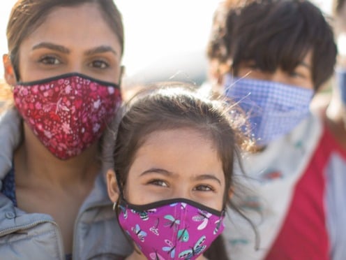 <span>A family wearing masks looking at the camera</span>
