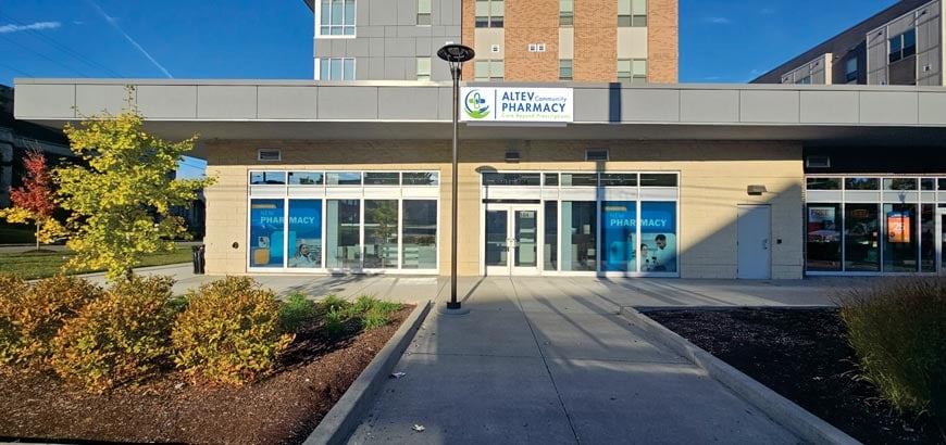 day time shot of corner of a building with a pharmacy on the ground floor