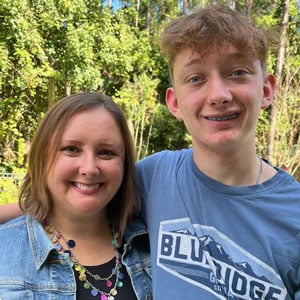 mother and son standing with arms around each other smiling