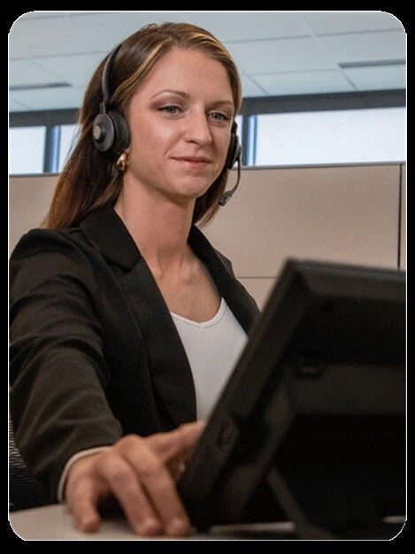 Woman at a computer wearing a telephone headset