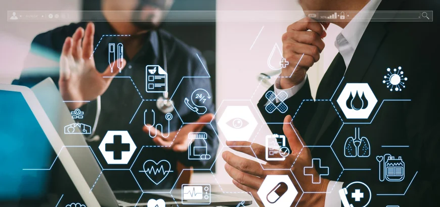 Two professionals discuss digital healthcare data on a tablet with medical icons overlay.